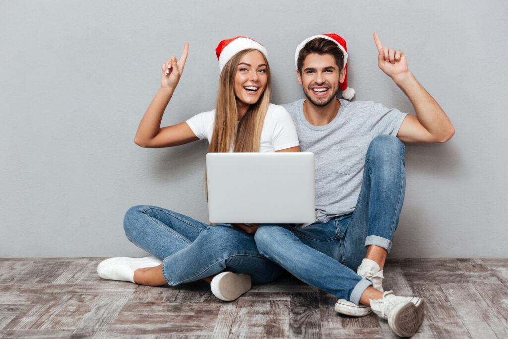 Graphicstock happy couple in christmas hats with laptop sitting down beautiful models bd8 ty 8hl
