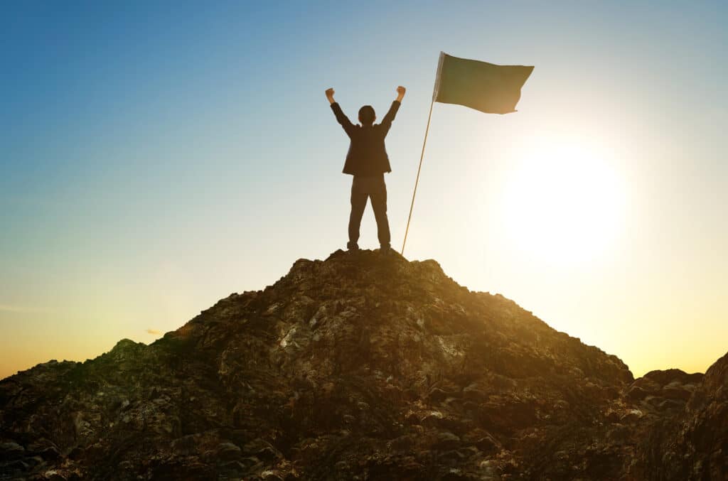 Graphicstock business success leadership achievement and people concept silhouette of businessman with flag on mountain top over sky and sun light background sollvyhpxjg